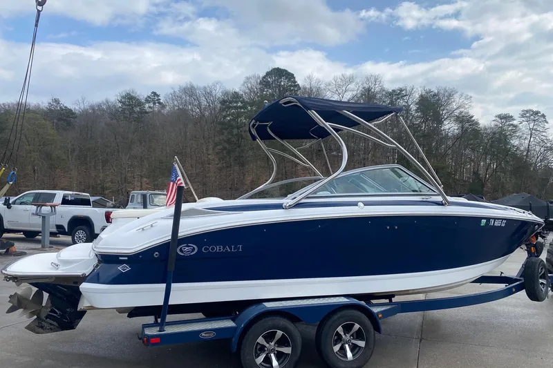 Slide: The Image of 2008 Cobalt 222 boat on trailer, parked outdoors with trees in the background. - 5
