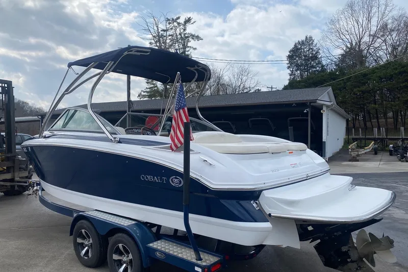 Slide: The Image of 2008 Cobalt 222 boat on trailer with American flag, parked outdoors. - 6