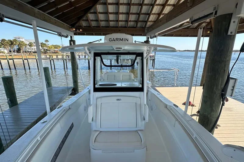 Slide: The Image of 2024 Sea Hunt Gamefish 30 Forward Seating boat docked under a wooden shelter. - 7