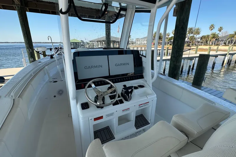 Slide: The Image of 2024 Sea Hunt Gamefish 30 boat cockpit with Garmin displays, docked by the water. - 9