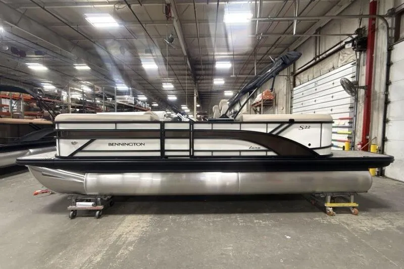 Slide: The Image of 2026 Bennington 22 SSRSE pontoon boat in a spacious indoor facility. - 0
