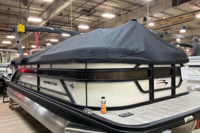 Slide: The Image of 2026 Bennington 22 SSRSE pontoon boat with cover in a warehouse setting. - 18