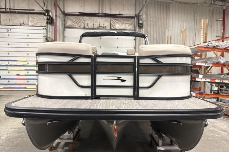 Slide: The Image of 2026 Bennington 22 SSRSE pontoon boat in a warehouse setting. - 2