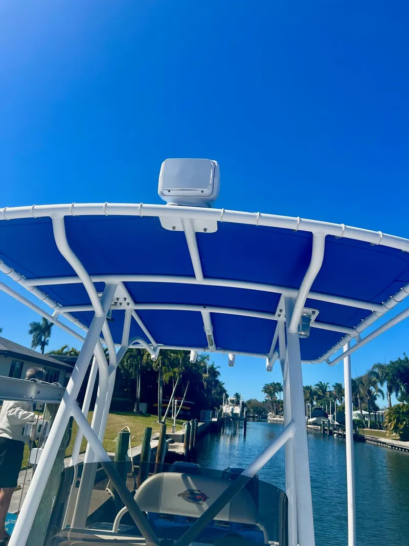 Slide: The Image of 2006 Concept 27 boat with blue canopy on waterway. - 14