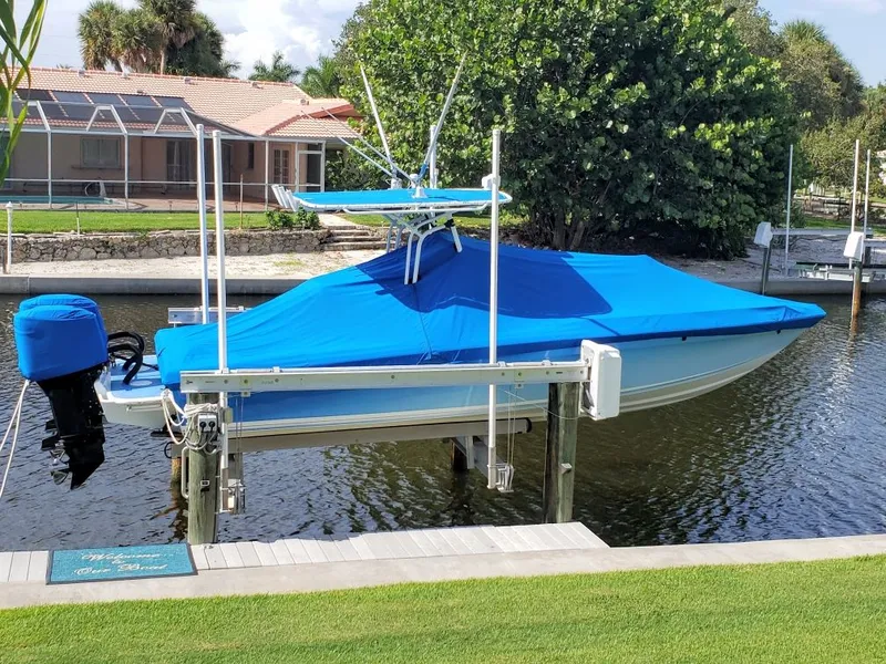 Slide: The Image of 2006 Concept 27 boat with blue cover on a boat lift. - 37