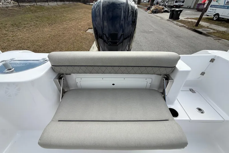 Slide: The Image of 2023 Sportsman Open 232 Center Console boat with cushioned seating and storage compartment. - 15