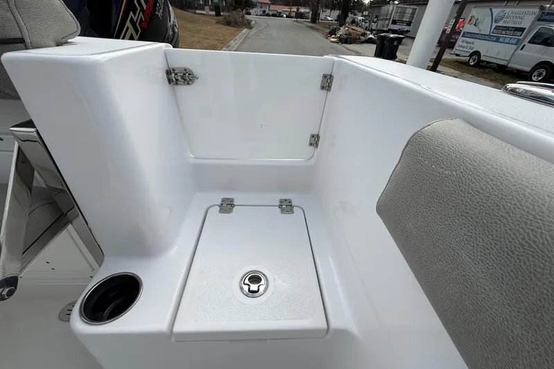 Slide: The Image of 2023 Sportsman Open 232 Center Console boat interior with storage compartment and cup holder. - 16