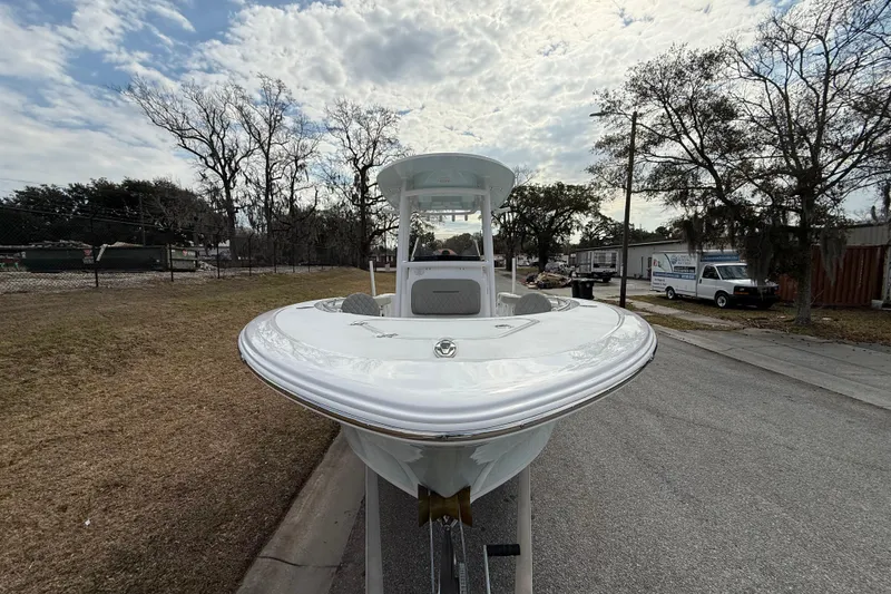 Slide: The Image of 2023 Sportsman Open 232 Center Console boat on trailer, parked on roadside. - 2