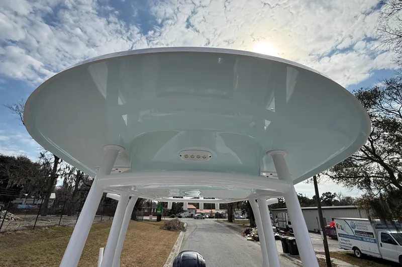 Slide: The Image of 2023 Sportsman Open 232 Center Console boat with T-top under a partly cloudy sky. - 22