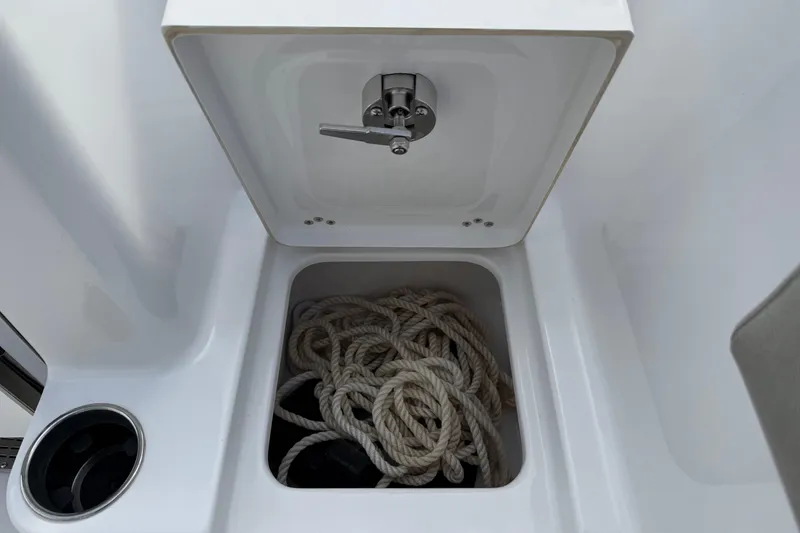 Slide: The Image of 2023 Sportsman Open 232 Center Console storage compartment with coiled rope inside. - 29