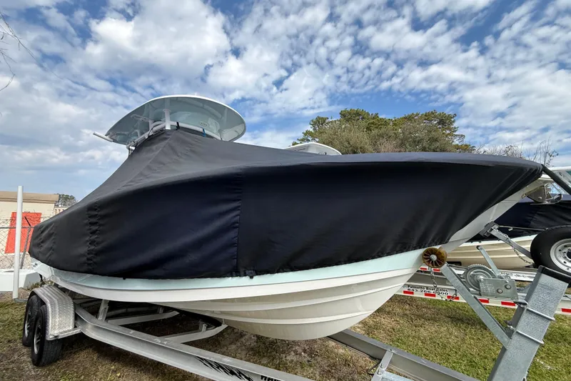 Slide: The Image of 2023 Sportsman Open 232 Center Console boat covered on trailer under cloudy sky. - 32