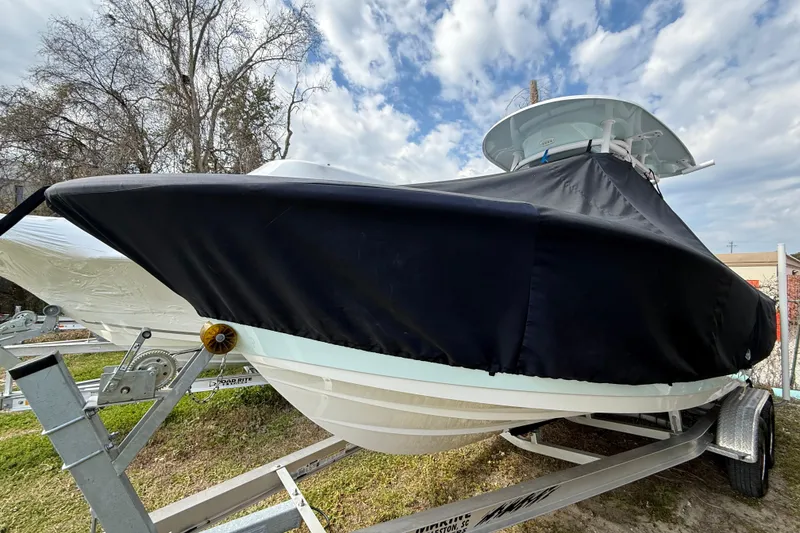Slide: The Image of 2023 Sportsman Open 232 Center Console boat covered on a trailer, outdoors. - 33