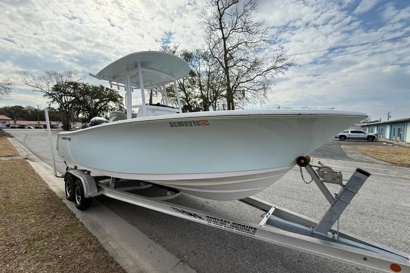 Slide: The Image of 2023 Sportsman Open 232 Center Console boat on trailer, parked on a street. - 4
