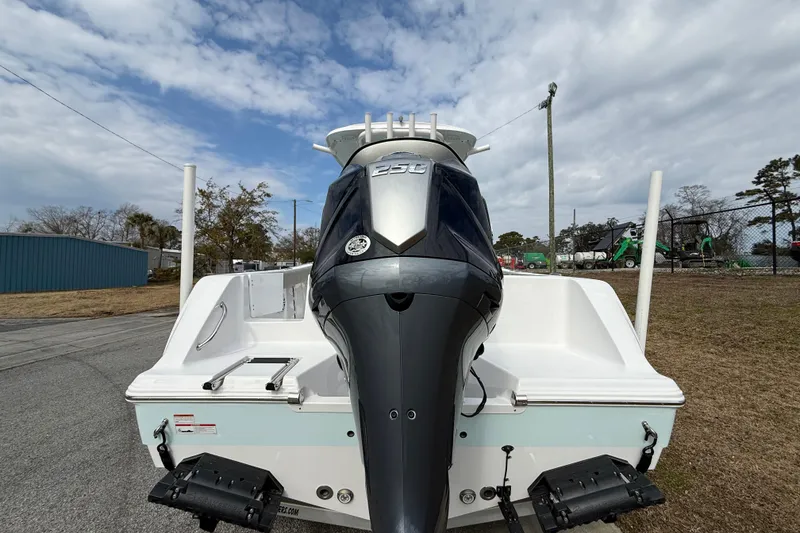 Slide: The Image of 2023 Sportsman Open 232 Center Console boat with powerful outboard motor, parked outdoors. - 5