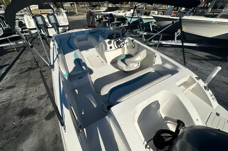 Slide: The Image of 2018 Starcraft Limited 2000 OB Fish boat with seating and steering wheel, docked outdoors. - 6