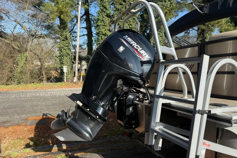 Slide: The Image of 2023 Bentley Pontoons 240 Navigator with Mercury outboard motor, parked outdoors. - 9