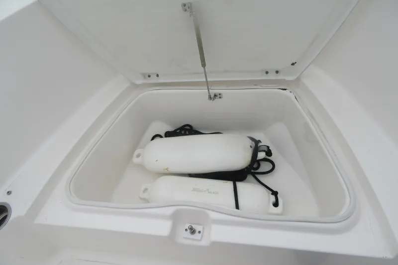 Slide: The Image of Open storage compartment on 2015 Robalo R180 Center Console boat with fenders inside. - 13
