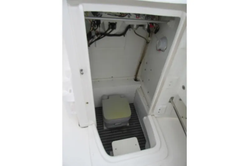 Slide: The Image of 2015 Robalo R180 Center Console storage compartment with portable toilet. - 14