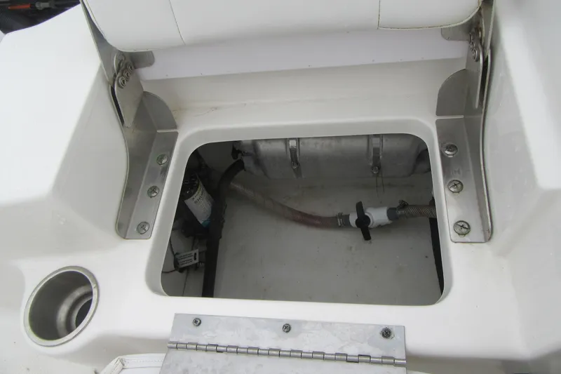 Slide: The Image of 2015 Robalo R180 Center Console boat storage compartment with visible plumbing and fittings. - 20
