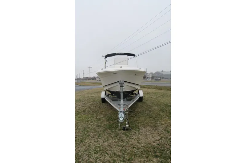 Slide: The Image of 2015 Robalo R180 Center Console boat on trailer, parked on grass. - 4