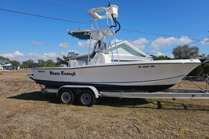 Slide: The Image of 1996 Mako 231 Center Console boat on trailer, parked outdoors under blue sky. - 10