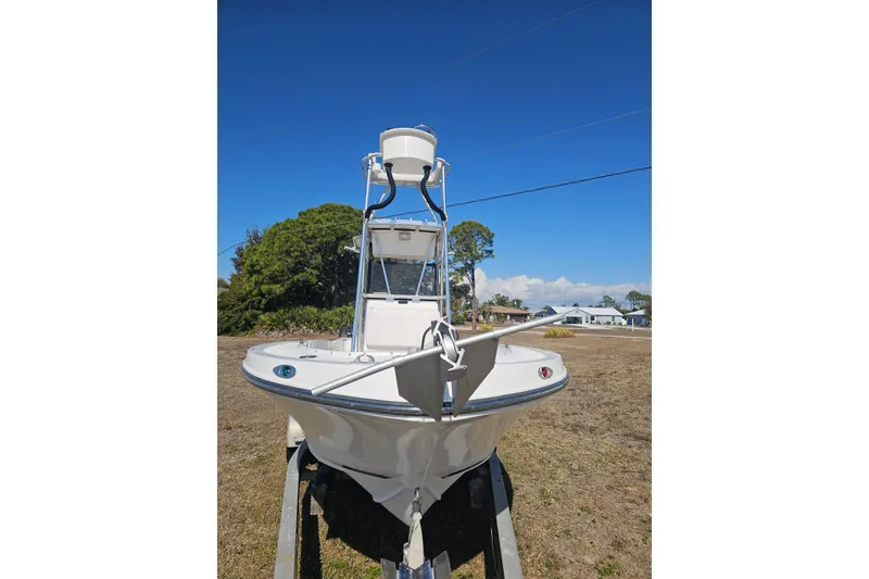 Slide: The Image of 1996 Mako 231 Center Console boat on trailer, clear sky background. - 13