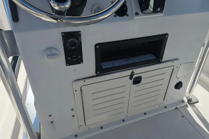 Slide: The Image of 1996 Mako 231 Center Console dashboard with steering wheel and control panel. - 20