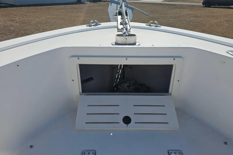 Slide: The Image of 1996 Mako 231 Center Console boat anchor storage compartment with open hatch. - 22