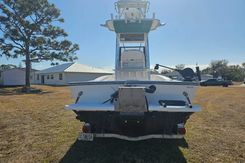 Slide: The Image of 1996 Mako 231 Center Console boat on grass, rear view with clear sky background. - 25