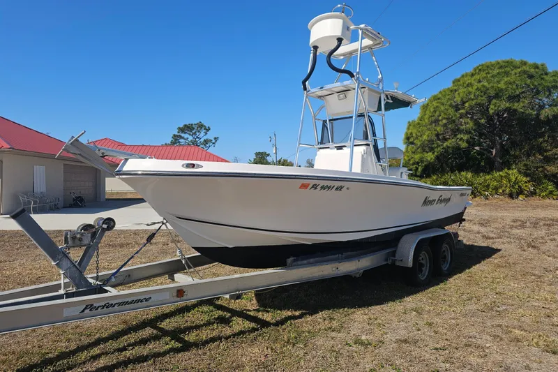 Slide: The Image of 1996 Mako 231 Center Console boat on trailer, parked outdoors under clear blue sky. - 27