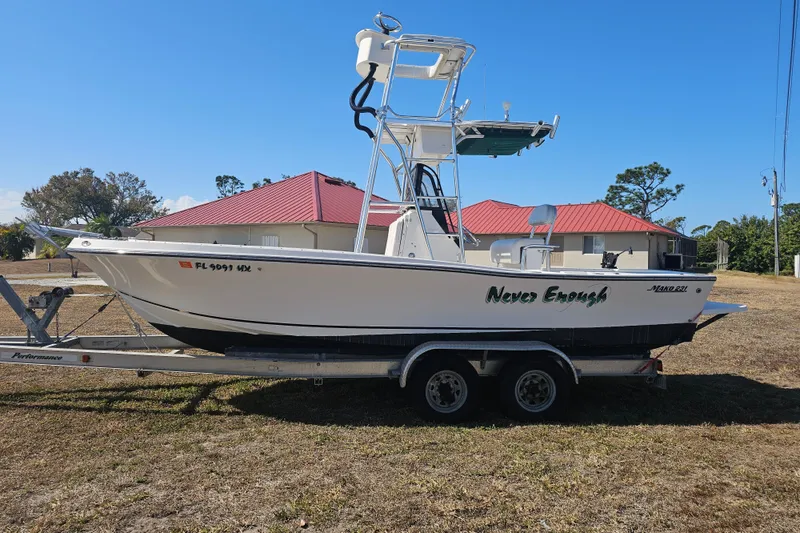 Slide: The Image of 1996 Mako 231 Center Console boat on trailer, parked outdoors under clear blue sky. - 28