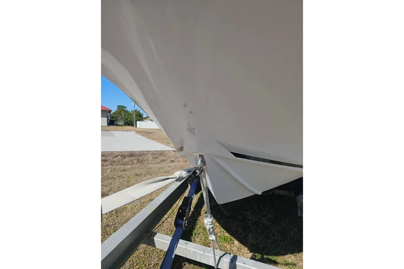 Slide: The Image of 1996 Mako 231 Center Console boat on trailer, showing hull and securing straps. - 29