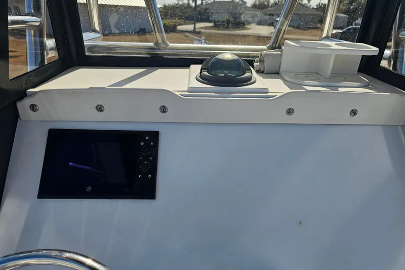 Slide: The Image of 1996 Mako 231 Center Console dashboard with compass and electronic display. - 37