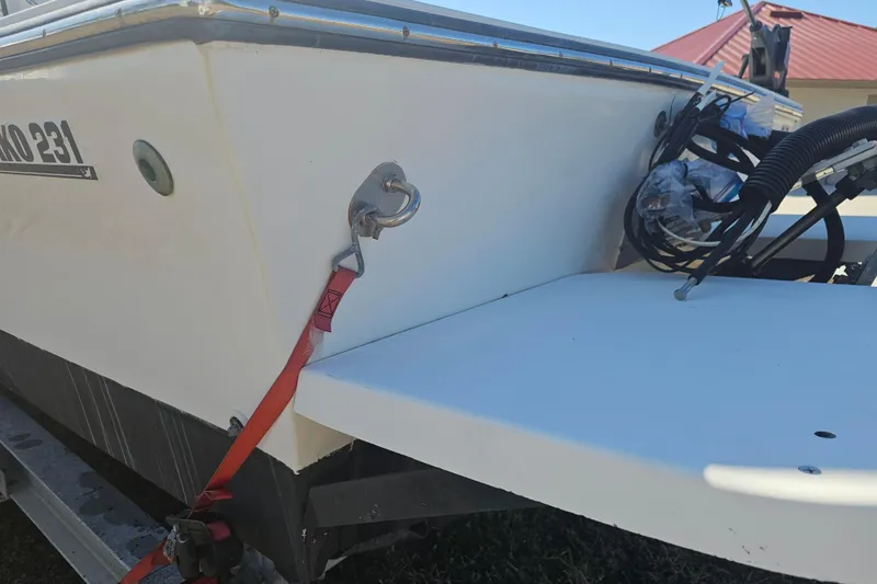 Slide: The Image of 1996 Mako 231 Center Console boat on trailer, showing stern details and red strap. - 49