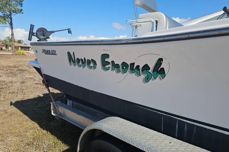 Slide: The Image of 1996 Mako 231 Center Console boat on trailer, named "Never Enough." - 5