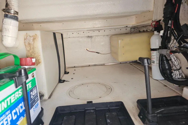 Slide: The Image of 1996 Mako 231 Center Console boat interior with battery and fire extinguisher. - 50