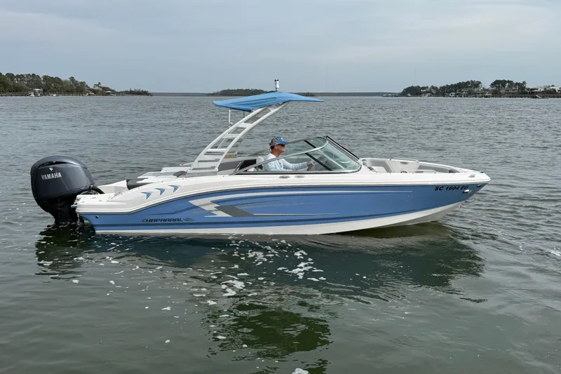 Slide: The Image of 2024 Chaparral 21 SSi OB boat on water, featuring sleek blue and white design. - 0