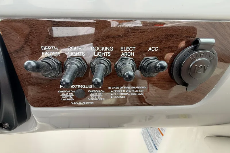 Slide: The Image of Control panel of 2024 Chaparral 21 SSi OB boat with switches and 12V outlet. - 14