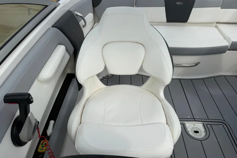 Slide: The Image of 2024 Chaparral 21 SSi OB boat interior with white captain's chair and gray flooring. - 17