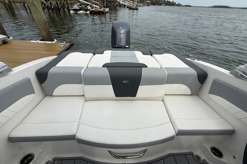 Slide: The Image of 2024 Chaparral 21 SSi OB boat with spacious seating, docked by the water. - 22