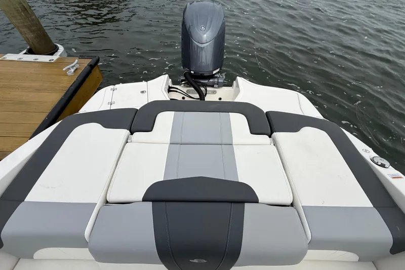 Slide: The Image of 2024 Chaparral 21 SSi OB boat with sleek seating and outboard motor on water. - 23