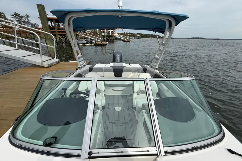 Slide: The Image of 2024 Chaparral 21 SSi OB boat docked, featuring sleek design and spacious interior. - 25