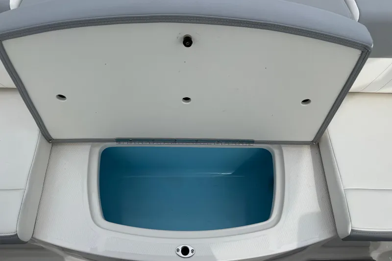 Slide: The Image of 2024 Chaparral 21 SSi OB boat storage compartment with open lid, showcasing interior space. - 29