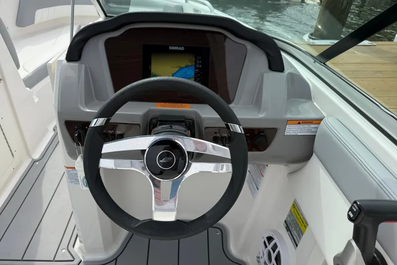 Slide: The Image of 2024 Chaparral 21 SSi OB boat dashboard with steering wheel and navigation display. - 9
