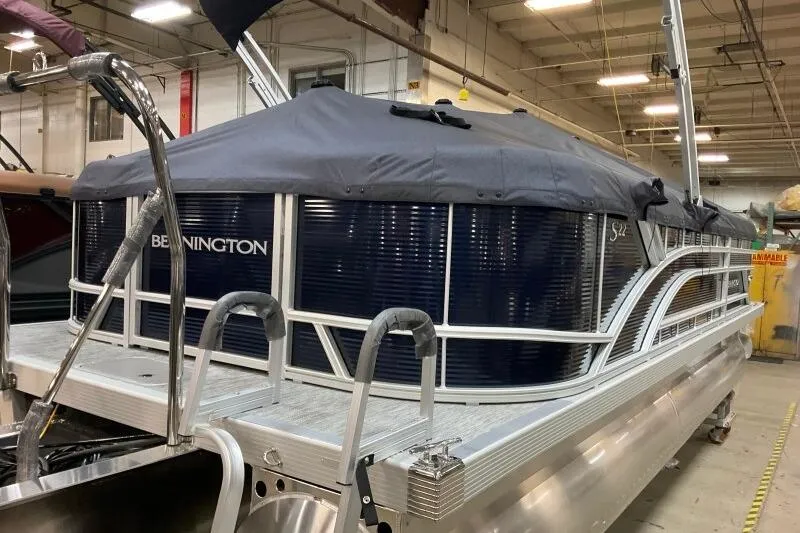 Slide: The Image of 2026 Bennington 22 SSRSF pontoon boat with cover in a warehouse setting. - 21
