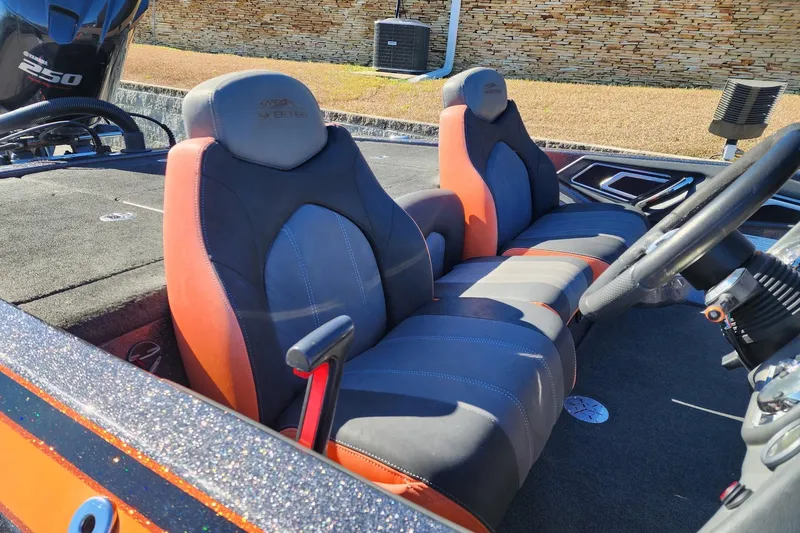 Slide: The Image of 2016 Skeeter FX20 boat interior with orange and gray seating, steering wheel, and Yamaha engine. - 3
