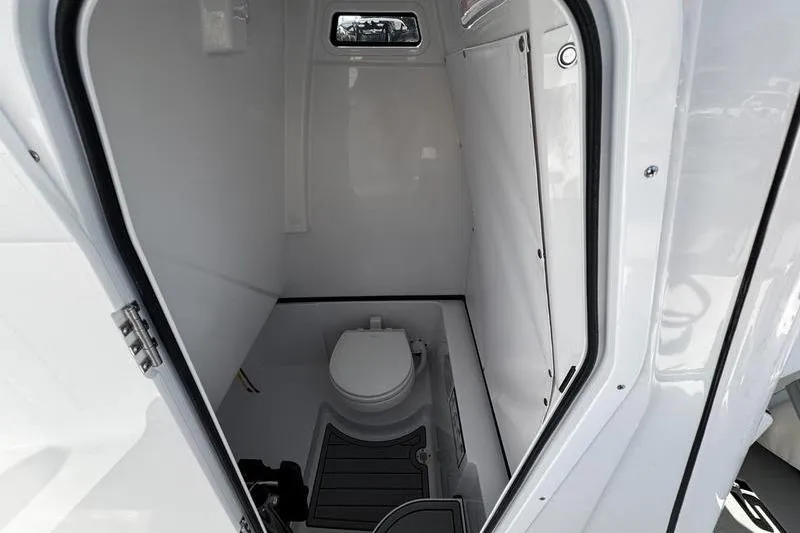 Slide: The Image of 2026 Sportsman Heritage 261 Center Console boat interior with compact marine toilet. - 16