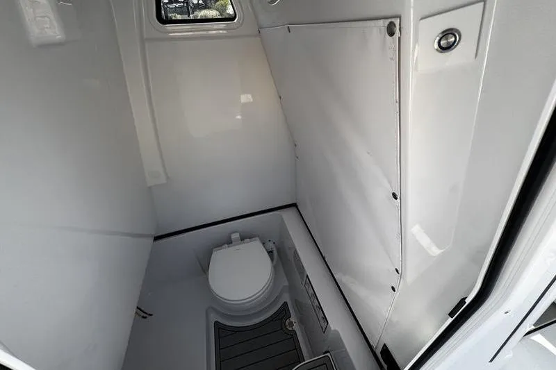 Slide: The Image of 2026 Sportsman Heritage 261 Center Console boat interior with compact marine toilet. - 17