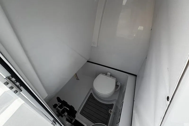 Slide: The Image of 2026 Sportsman Heritage 261 Center Console boat interior with compact marine toilet. - 18