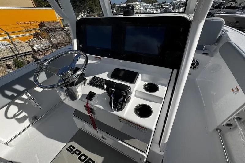 Slide: The Image of 2026 Sportsman Heritage 261 Center Console boat dashboard with steering wheel and controls. - 19